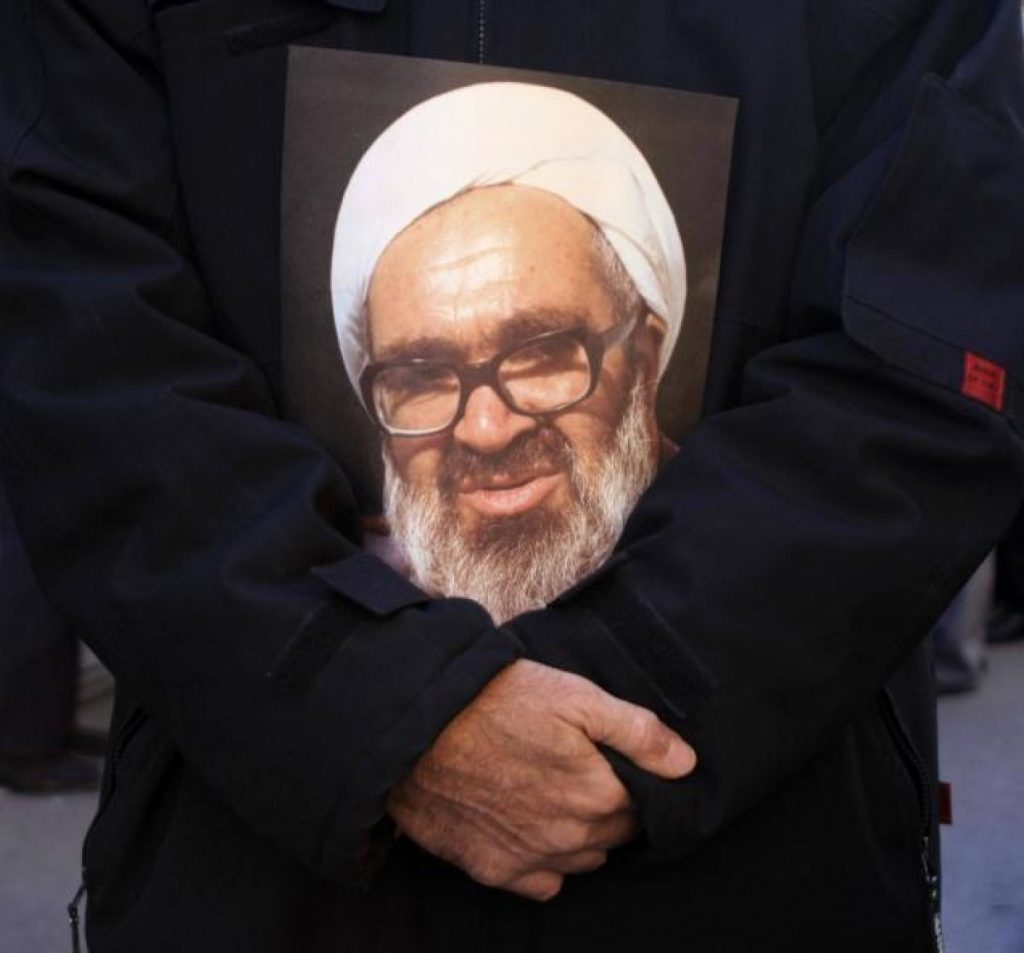A mourner holds a poster of Ayatollah Hossein Ali Montazeri at the cleric's funeral in 2009. (Associated Press).